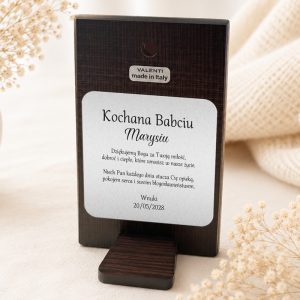 Tabliczka z napisem "Kochana Babciu Marysiu" z podziękowaniami i datą 20/05/2028, na tle dekoracyjnych kwiatów.