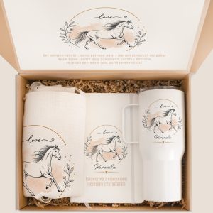 Zestaw prezentowy z ilustracją konia, kubkiem termicznym i torbą na tle ozdobnego papieru. W środku napis "Dziewczyna z marzeniami i końskim charakterem".