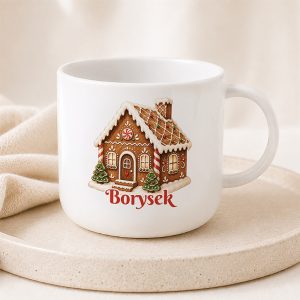 Świąteczny kubeczek wielorazowy wykonany z plastiku. Kubek ozdobiony jest grafiką zimowej chatki z piernika.