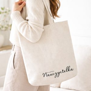 Płócienna torba dla nauczycielki z eleganckim czarnym nadrukiem, praktyczny prezent na Dzień Nauczyciela.